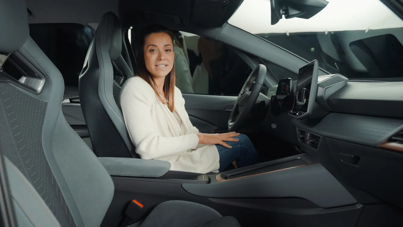 Eine Frau sitzt beim Fotoshooting in einem CUPRA Born.