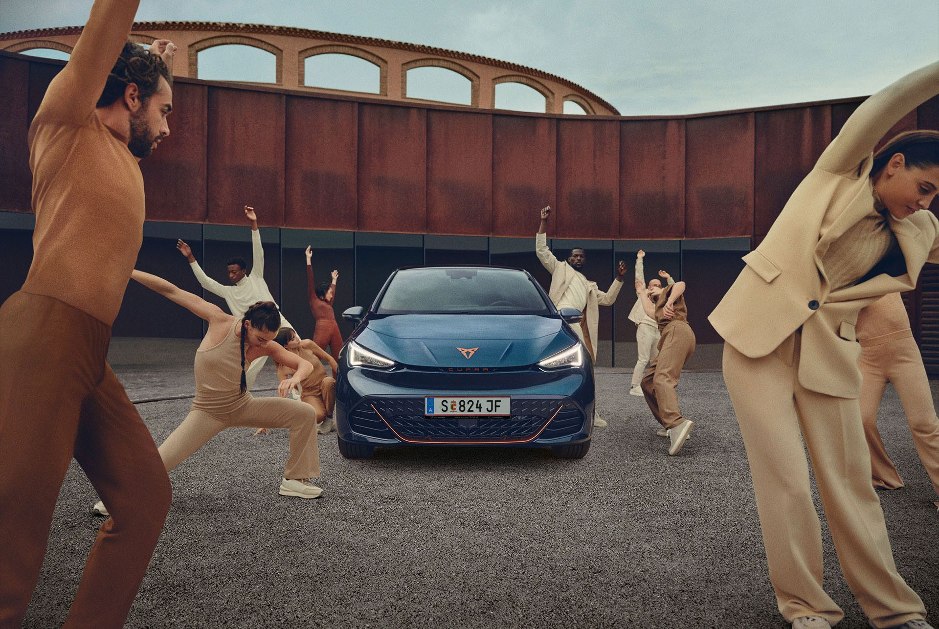 Tänzer posieren um einen blauen CUPRA Born.